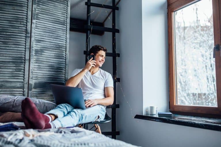 man using laptop in his bedroom