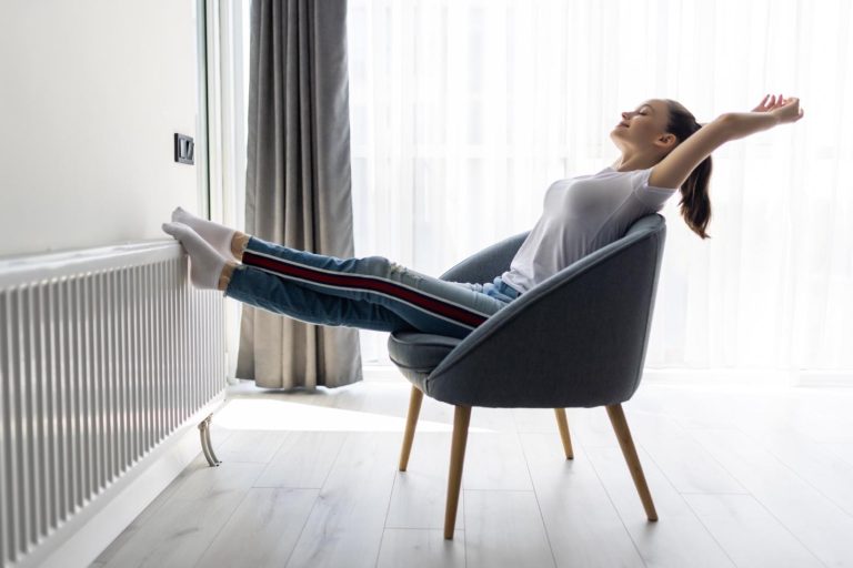 A person sitting in a chair with her legs up Description automatically generated