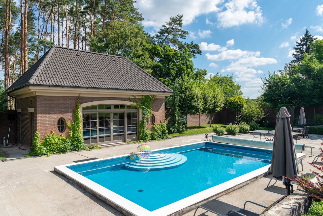 Free Elegant poolside setup with a modern patio, ideal for summer relaxation. Stock Photo