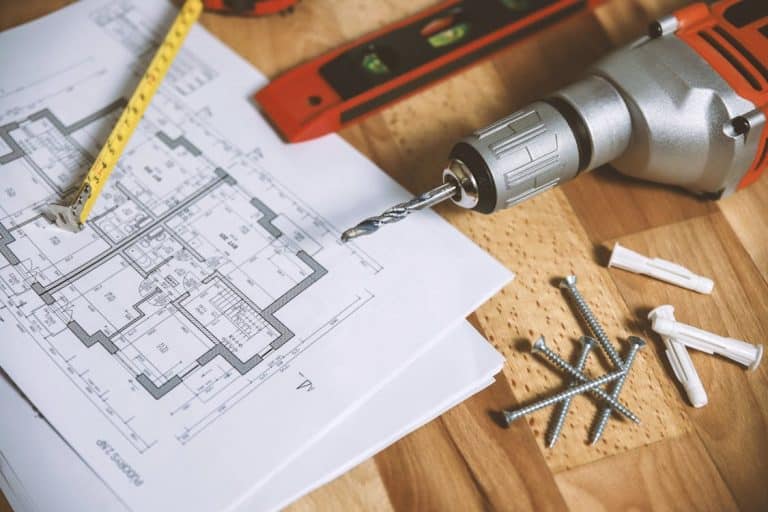 Free Close-up of construction blueprint with tools like drill and screws on a wooden table. Stock Photo
