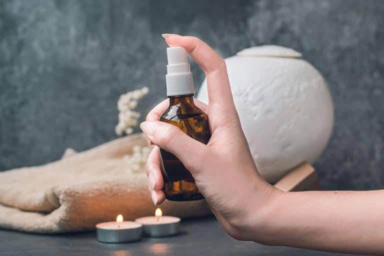 A woman spraying a mixture of water and peppermint essential oil