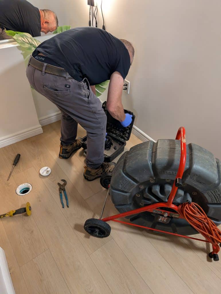 A mam assembling a wheeled device inside a room