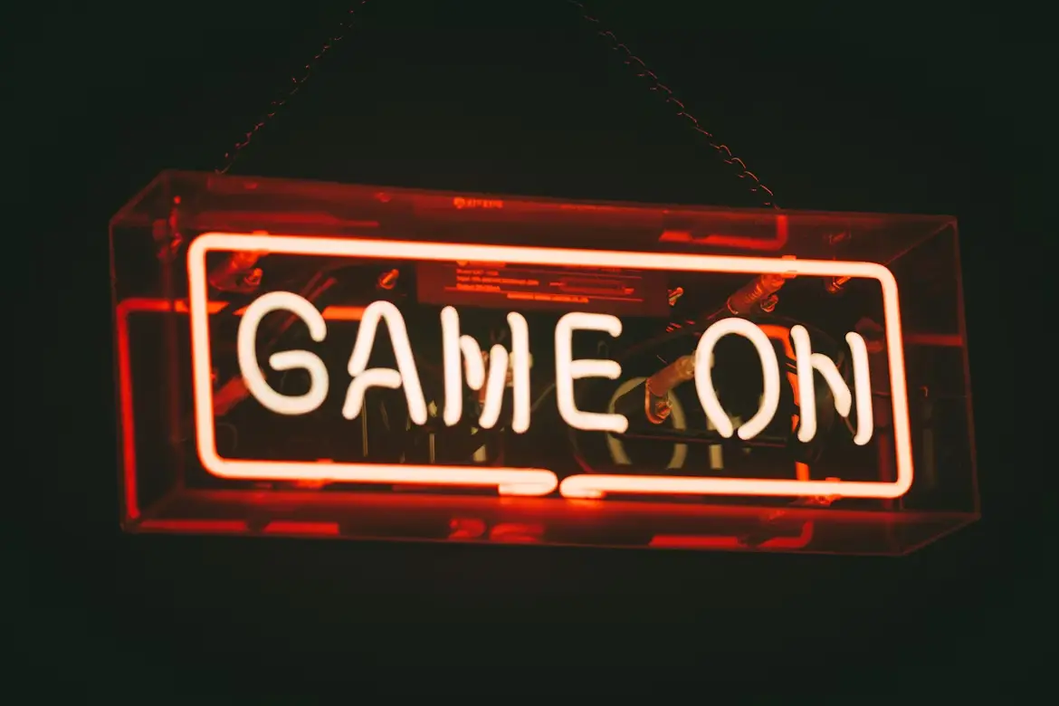 Neon sign displaying "Game On" in bright orange glow against dark background
