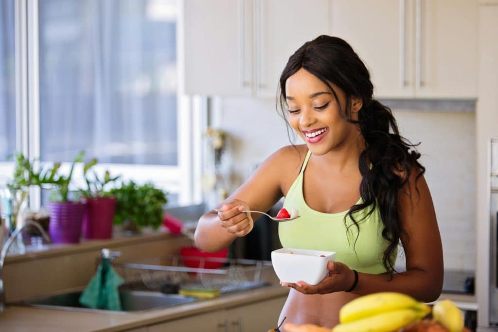 A woman eating from a white bowl