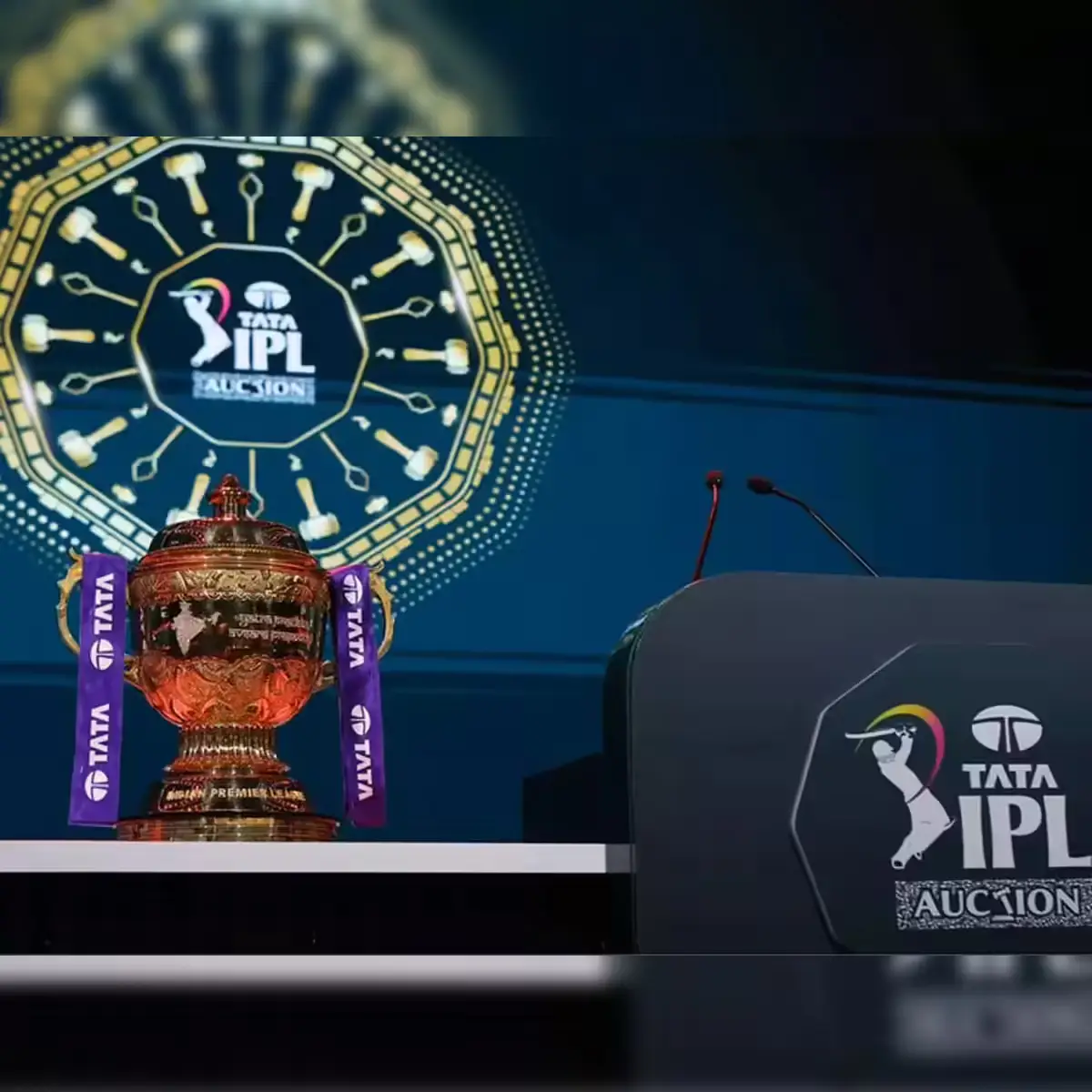 IPL trophy displayed on stage with podium and blue illuminated background