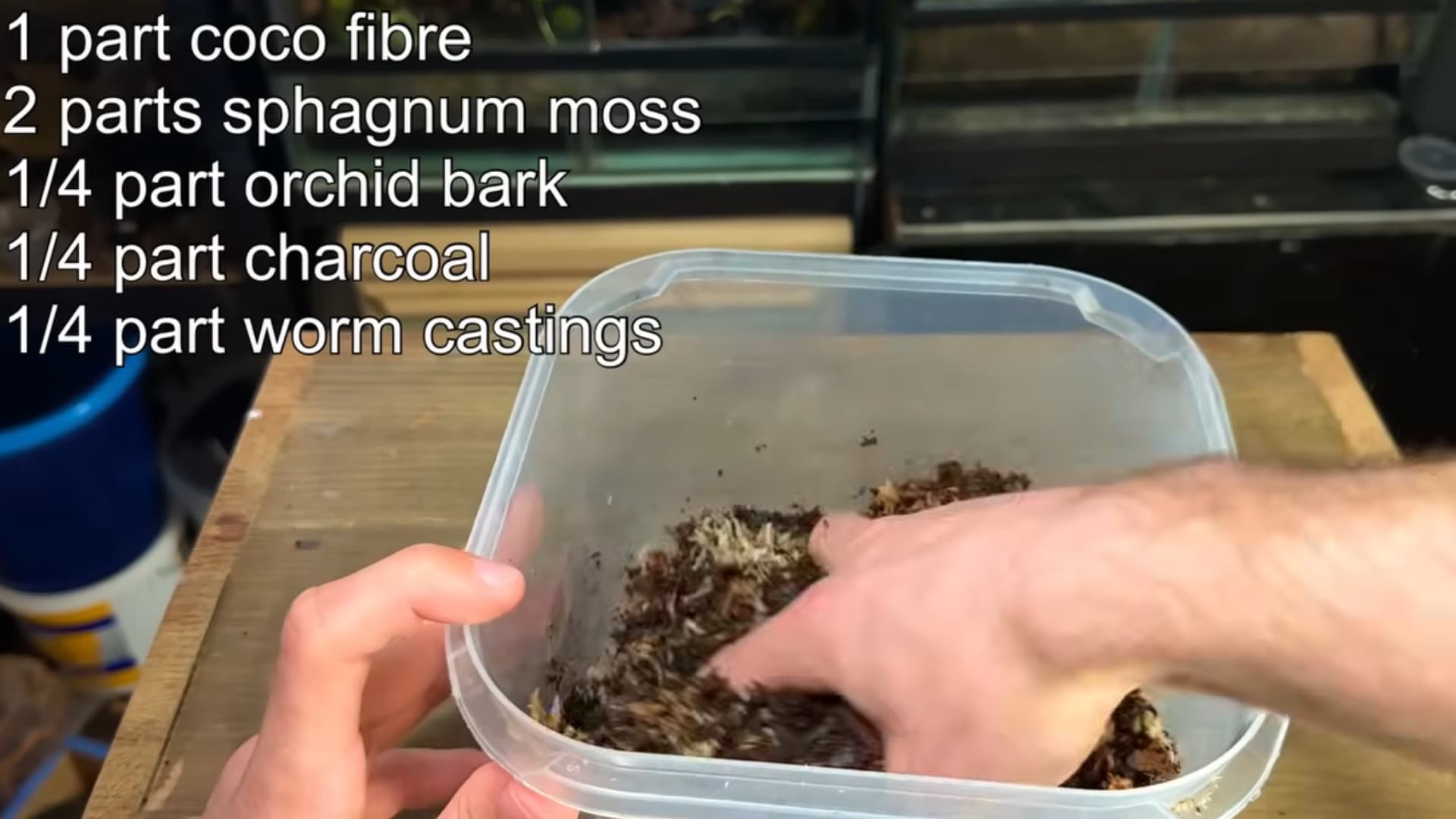 A hand mixes a container with a mixture of coco fiber, sphagnum moss, orchid bark, charcoal, and worm castings, with a list of ingredients visible beside it.