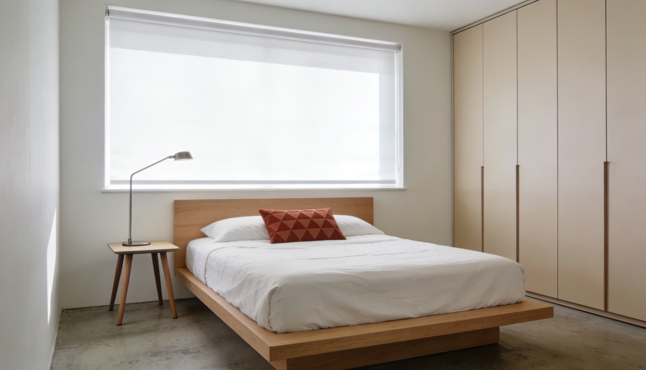 Minimalist Bauhaus bedroom featuring a low wooden platform bed, clean white bedding, a simple wooden nightstand, and sleek built-in wardrobes.