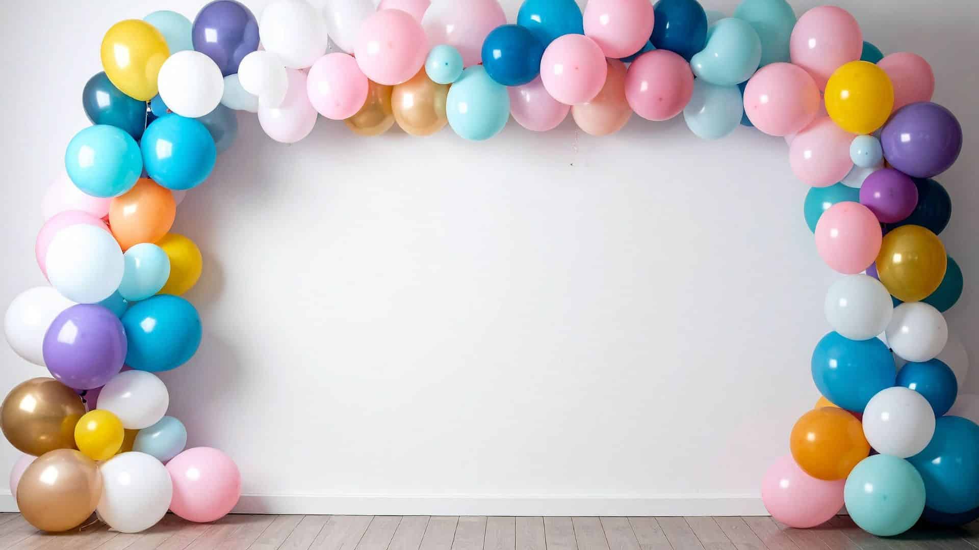 Colorful balloon garland arranged on wall, showing how to hang balloons on wall for parties using tape strips, hooks, or adhesive methods