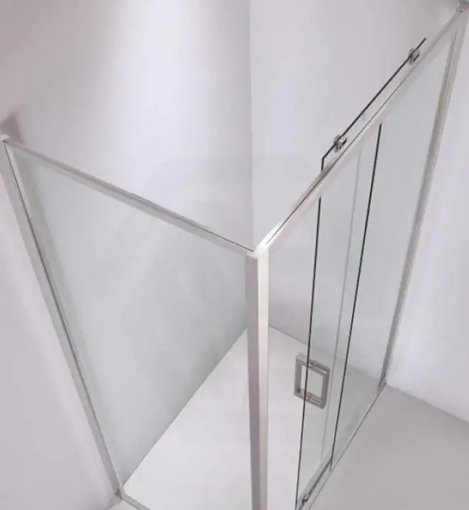 Glass shower enclosure with chrome frame in white bathroom corner