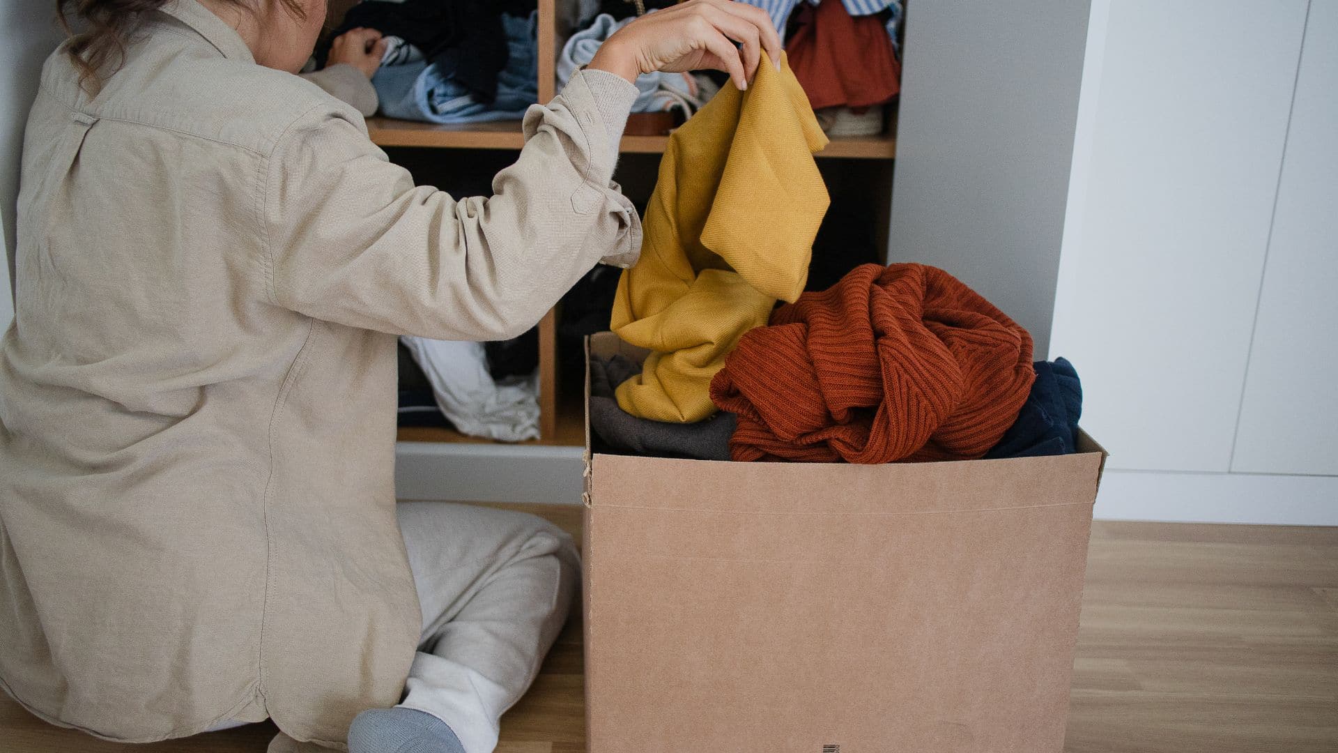 How to declutter your home by sorting clothes into a donation box, organizing wardrobe items, and removing clutter for a cleaner, tidy space