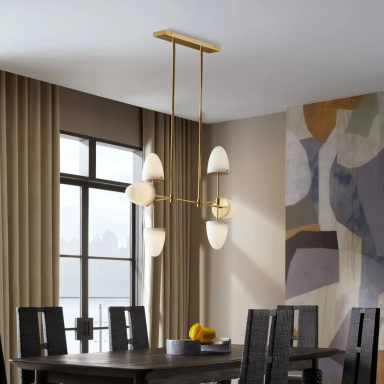 Modern dining room with brass chandelier, abstract wall art, and dark wood table with fruit centerpiece