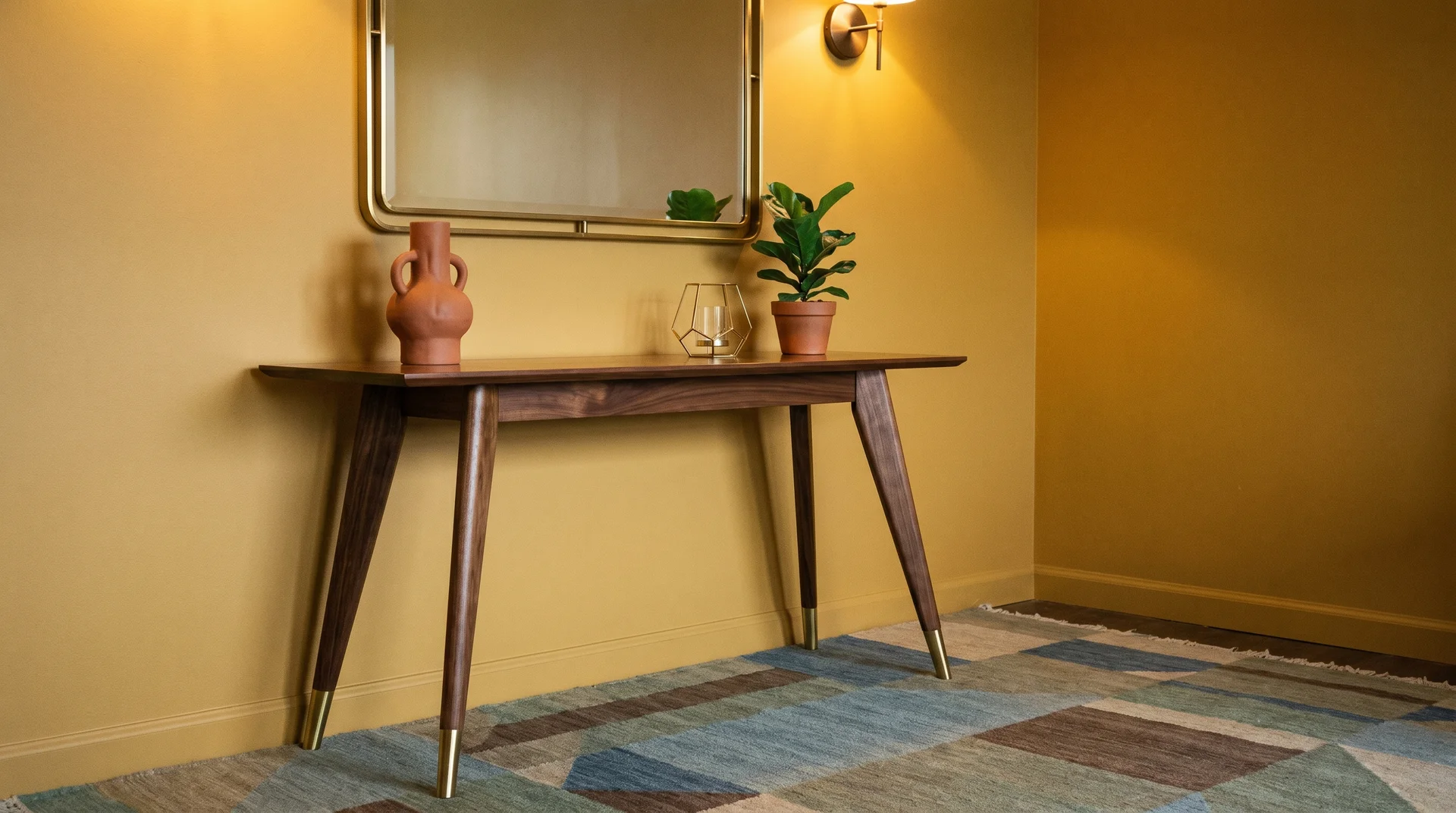 Mid-century modern console table with tapered legs against a yellow wall, styled with a vase, potted plant, and mirror above.