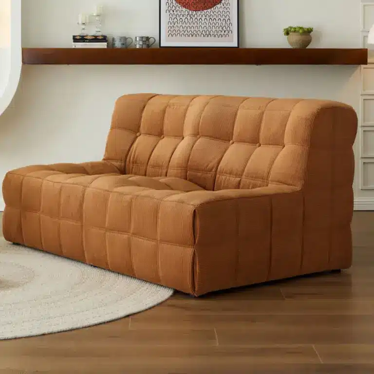 Tufted brown sofa on wooden floor in cozy living room with wall shelf and decor