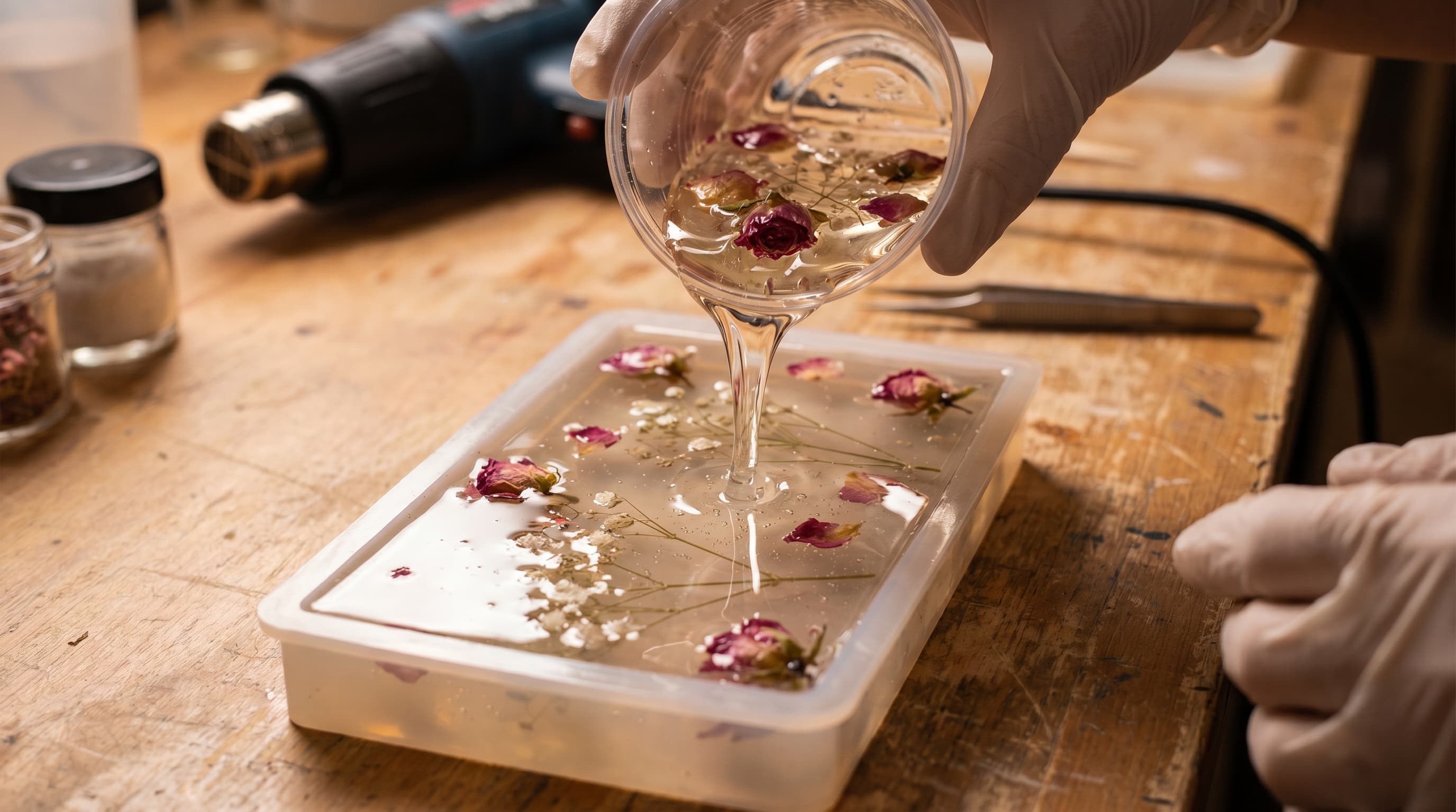 Dried flowers suspended inside clear epoxy resin being poured into a silicone mold on a wooden craft table, with realistic reflections, visible petals, and a detailed DIY resin preservation setup.