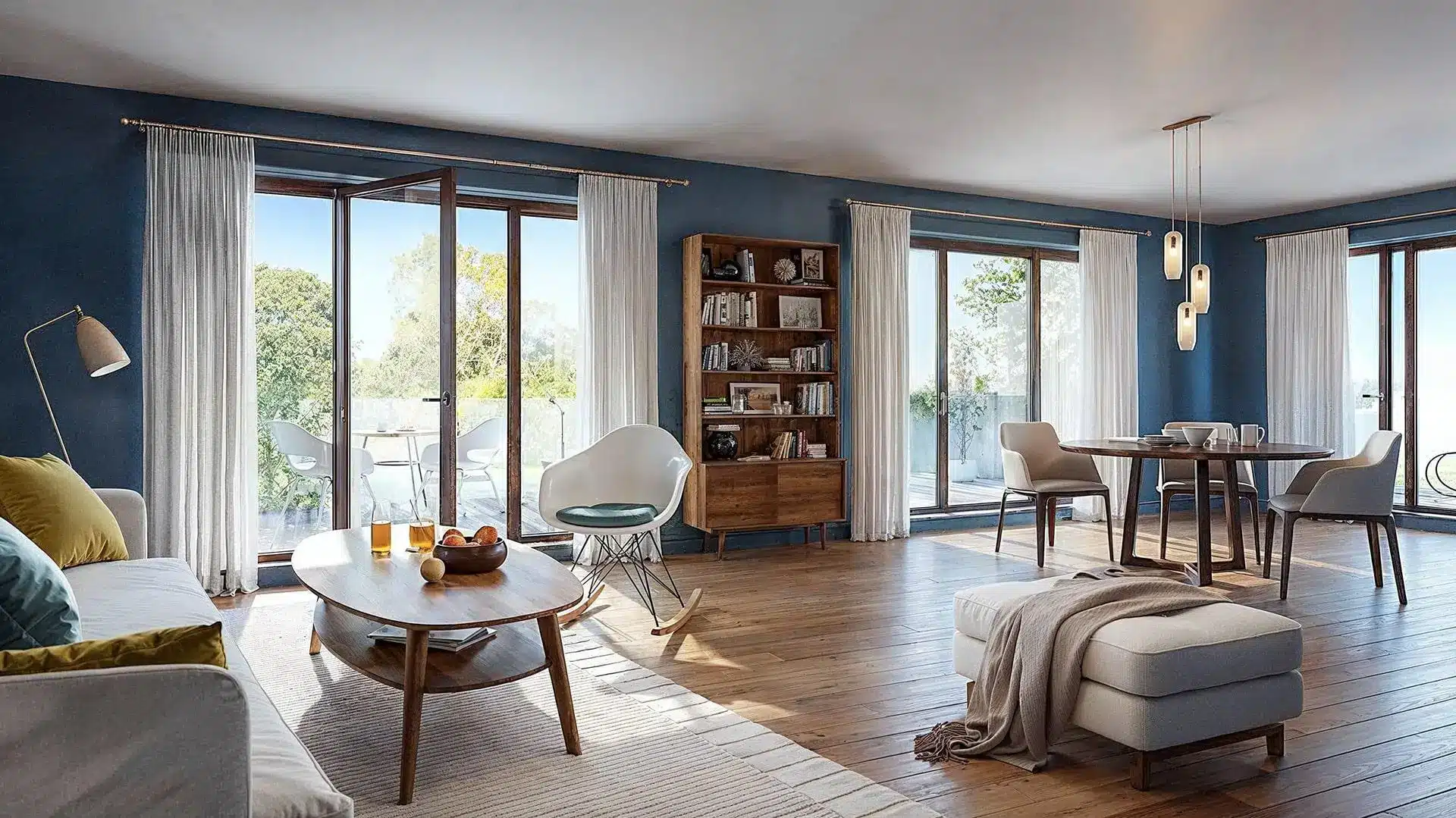 Modern living room with blue walls, wooden furniture, and large windows overlooking a patio
