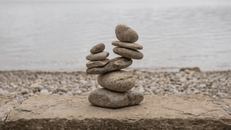 Balanced stones on a flat surface showing asymmetry in arrangement