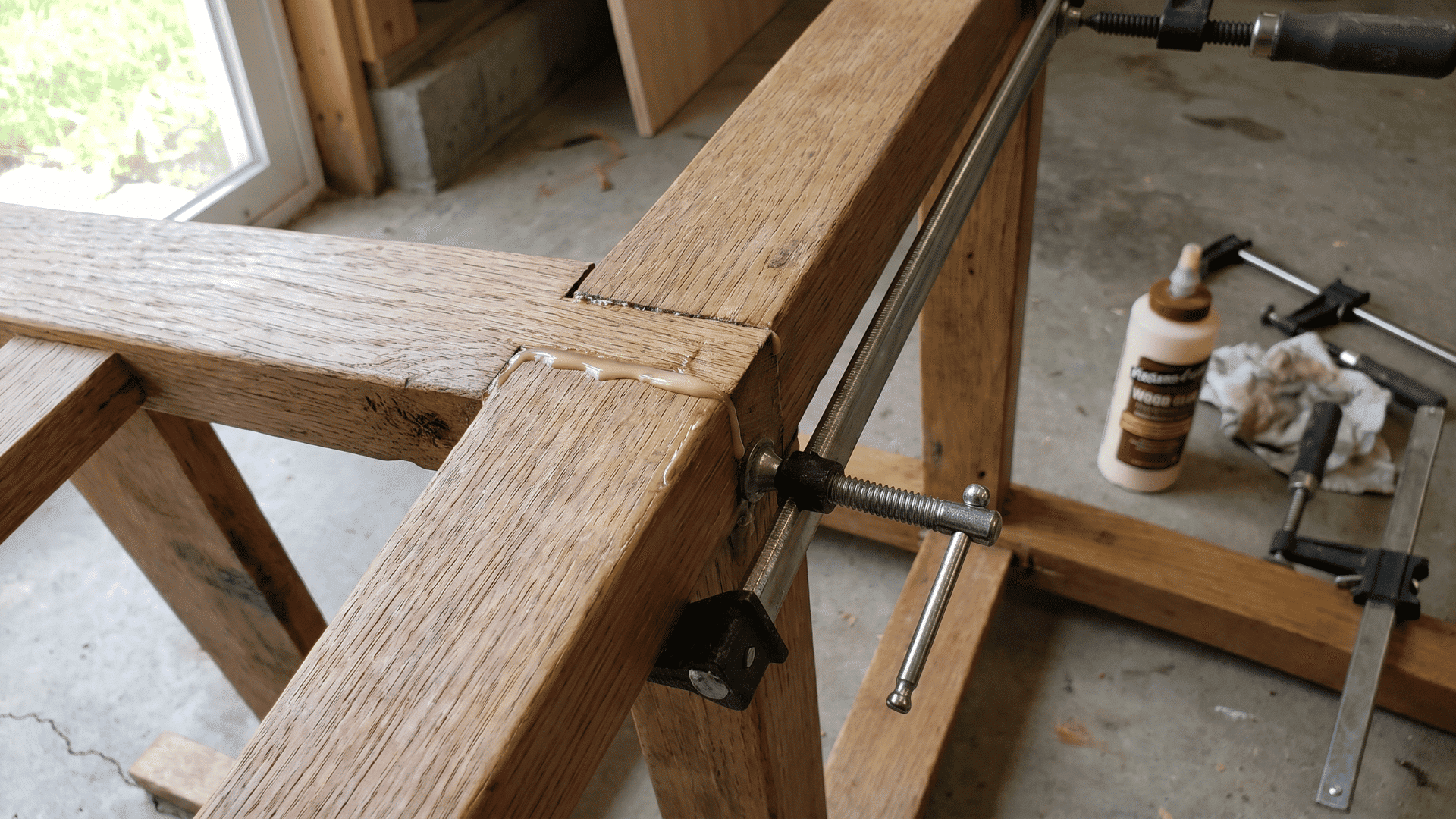 Clamp securing a glued wooden chair joint during furniture repair