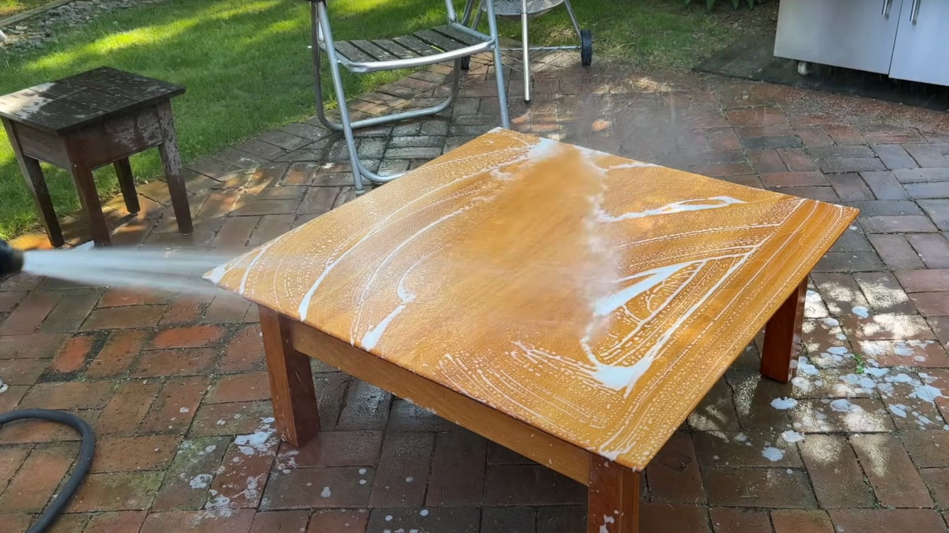 Cleaning and sanding the flat surface of a light wood board with fine-grit sandpaper.