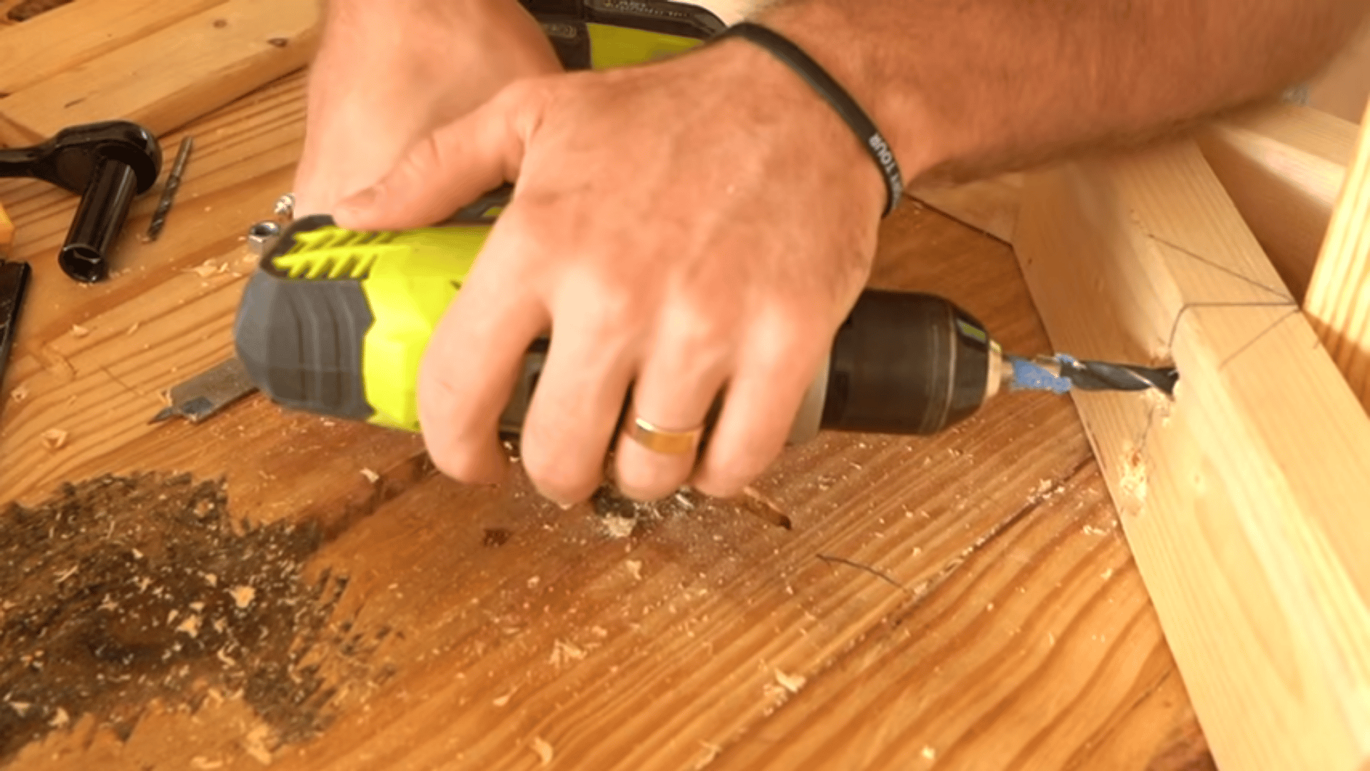 close-up-of-hands-using-a-lime-green-power-drill-to-bore-a-pocket-hole-into-a-wooden-beam
