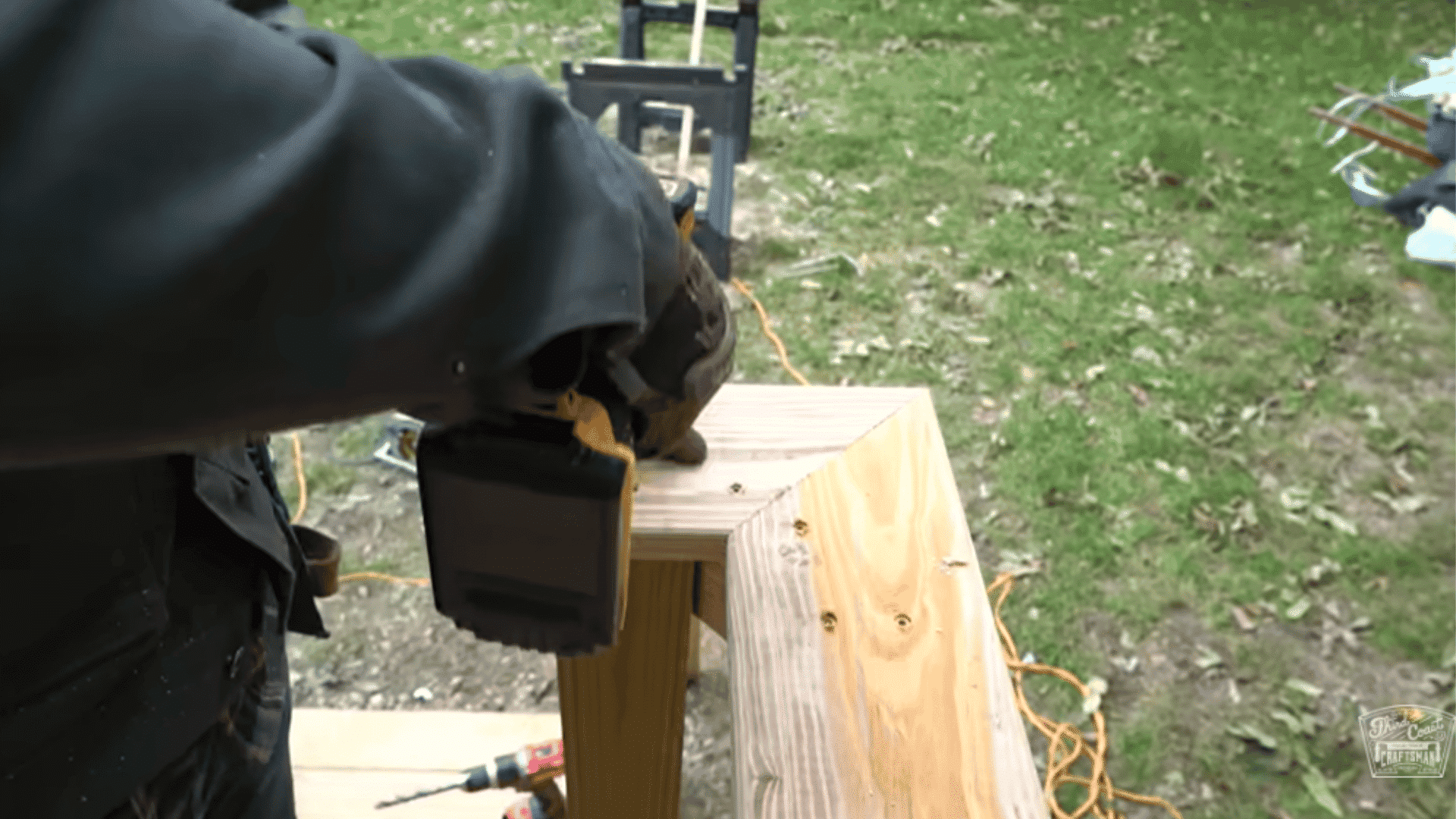 Drill being used to attach a wooden cap to the top of a deck railing post