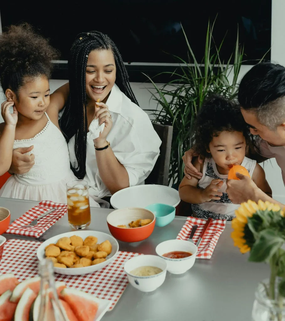 Family enjoying meal together with children at a table set with snacks and drinks