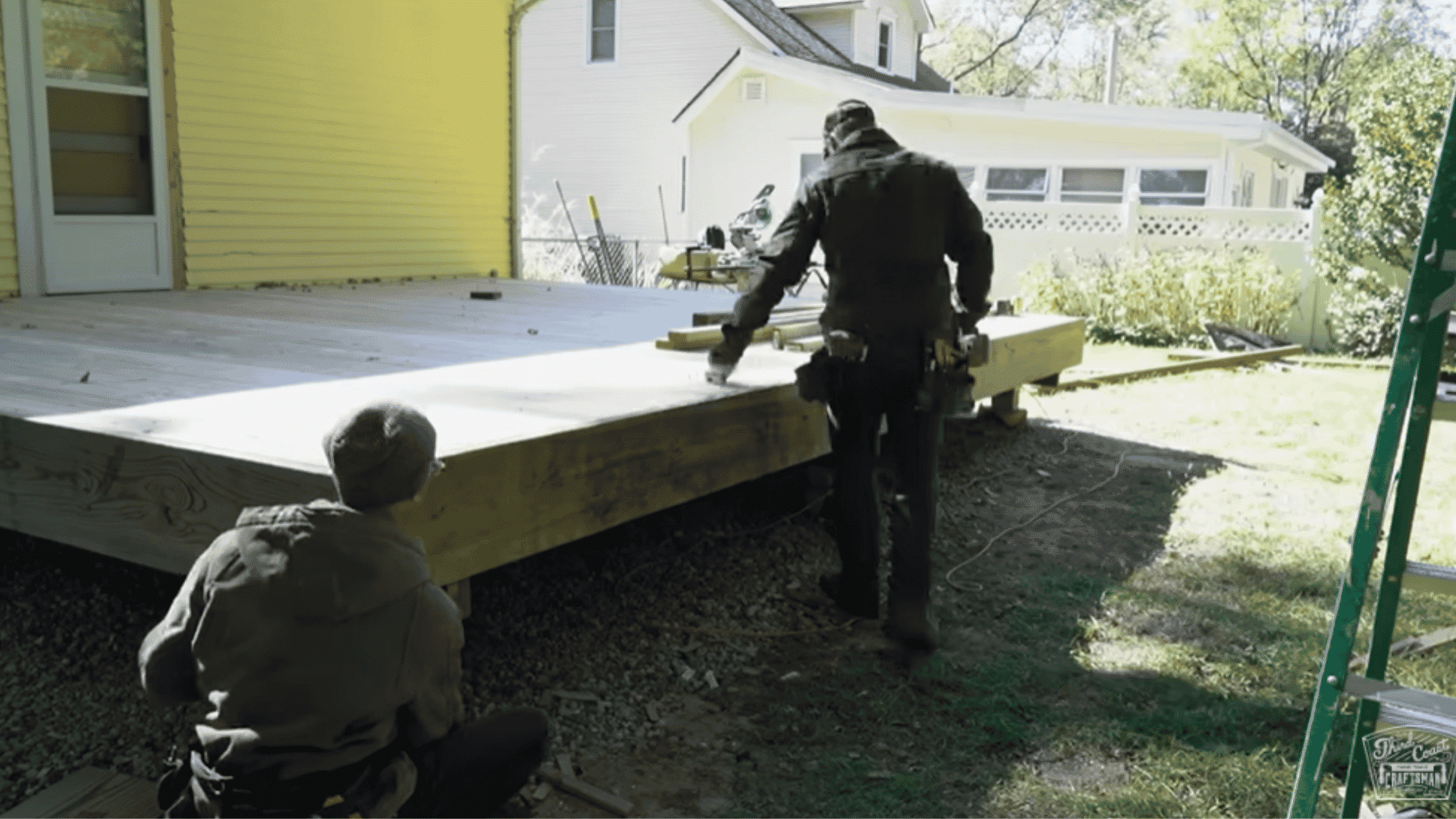 Finished deck platform installed with two people working near the edges