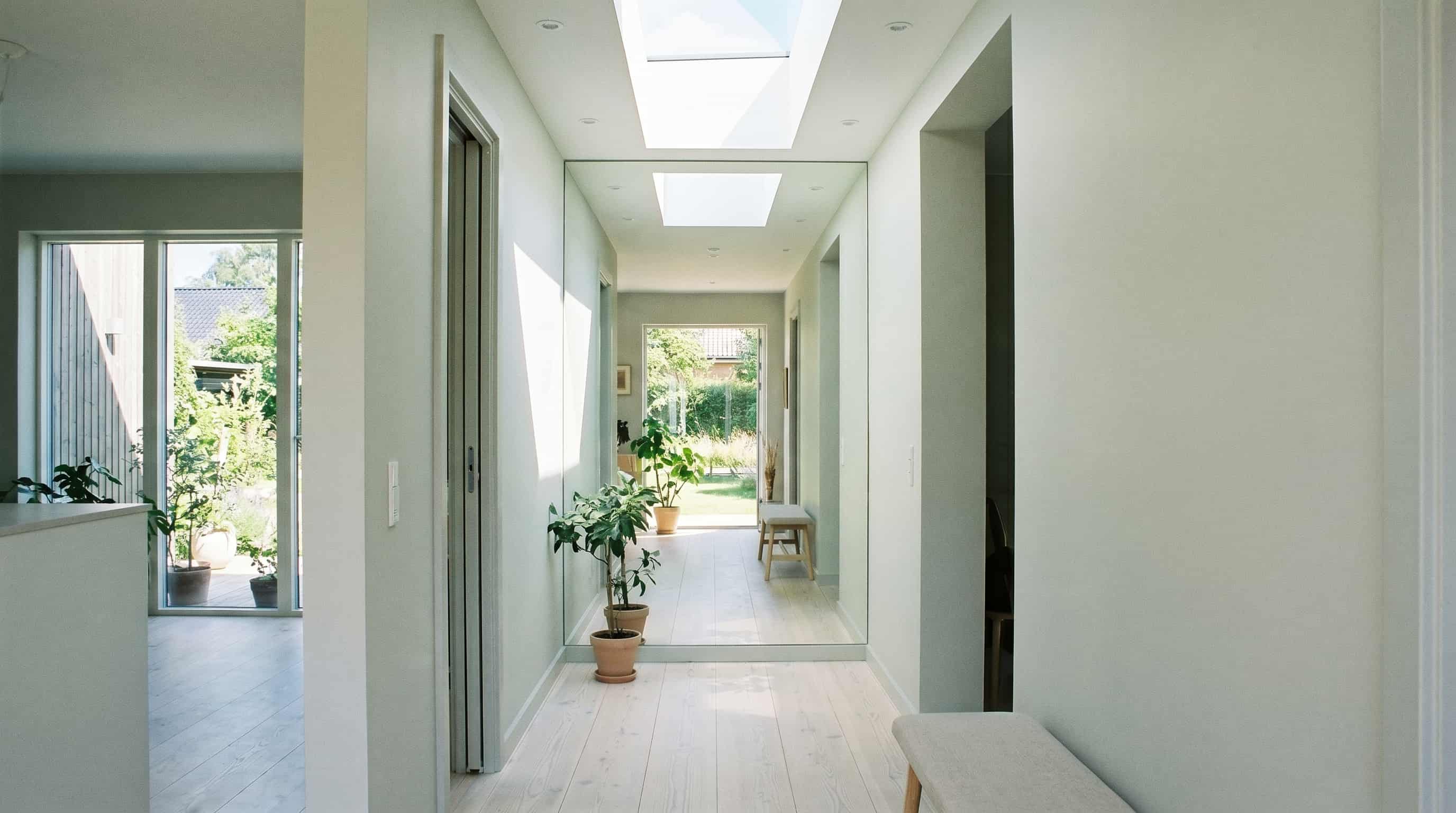 Bright hallway decor ideas incorporating a full-length mirror to reflect natural light and visually expand the space.