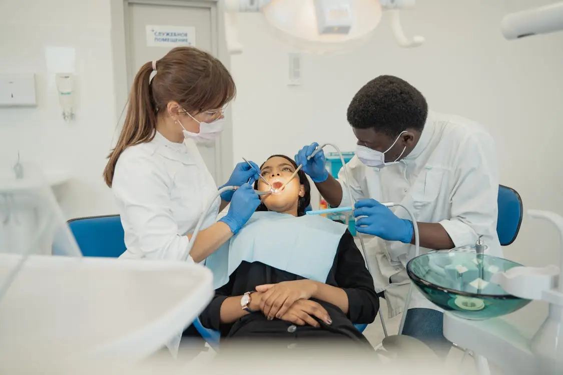 Dentists performing dental procedure on patient in a bright clinic with modern equipment