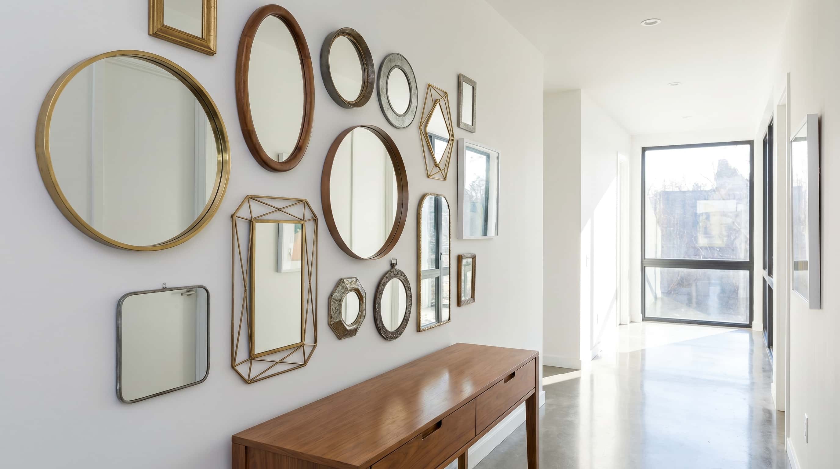 Stylish hallway decor ideas featuring a mixed mirror grouping that adds depth, brightness, and decorative interest.
