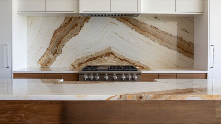 A spectacular luxury kitchen featuring a translucent, glowing backlit natural onyx slab backsplash.