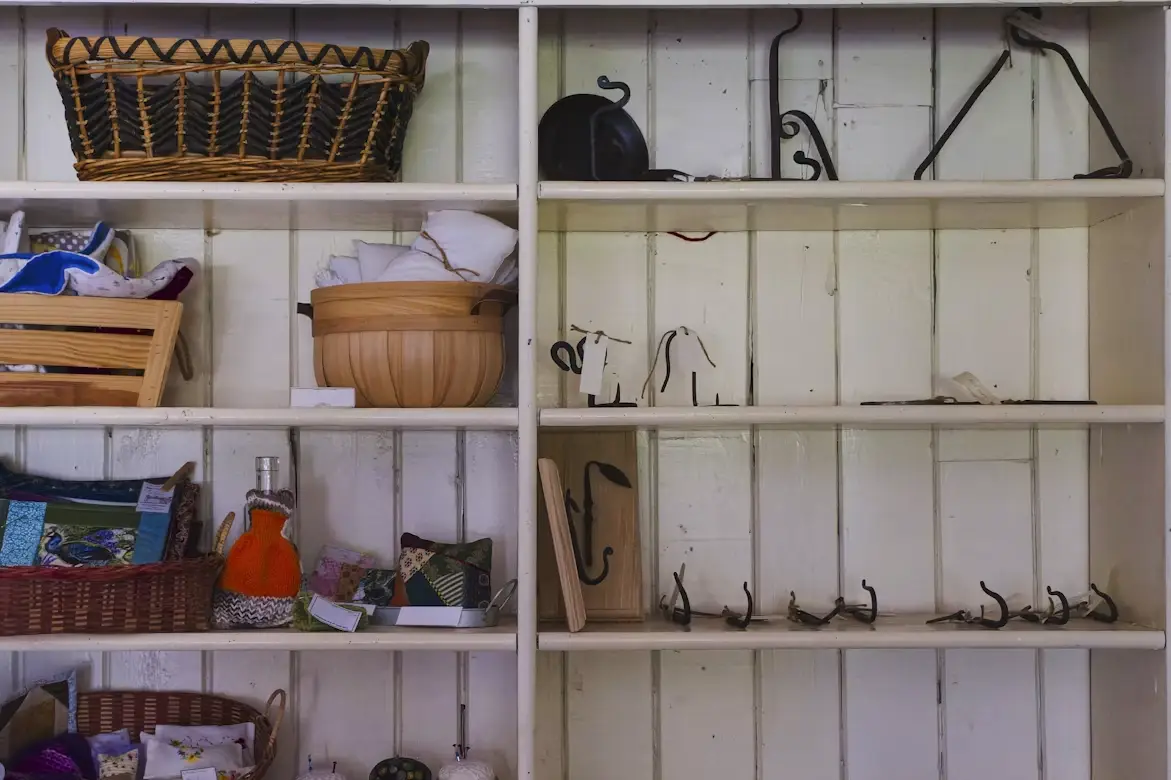 Wooden shelves displaying woven baskets, fabric, and metal hooks in a rustic setting