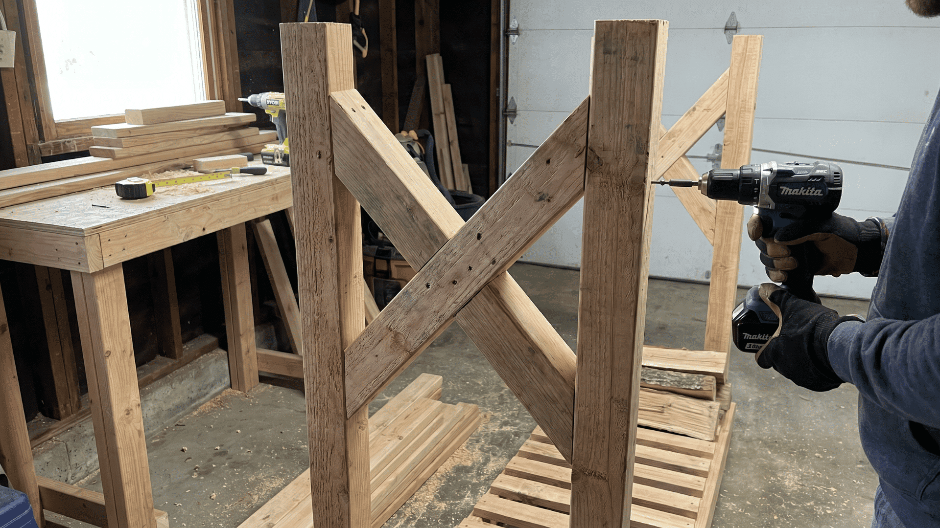 Person securing cross braces on a wooden firewood rack with a drill