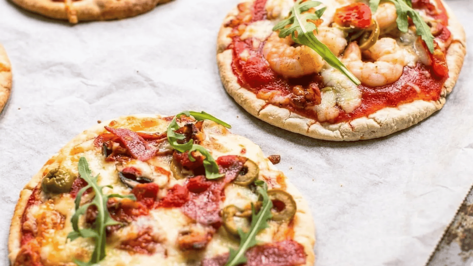 Personal pita pizzas topped with melted cheese, fresh veggies, and savory meats for an easy family dinner.