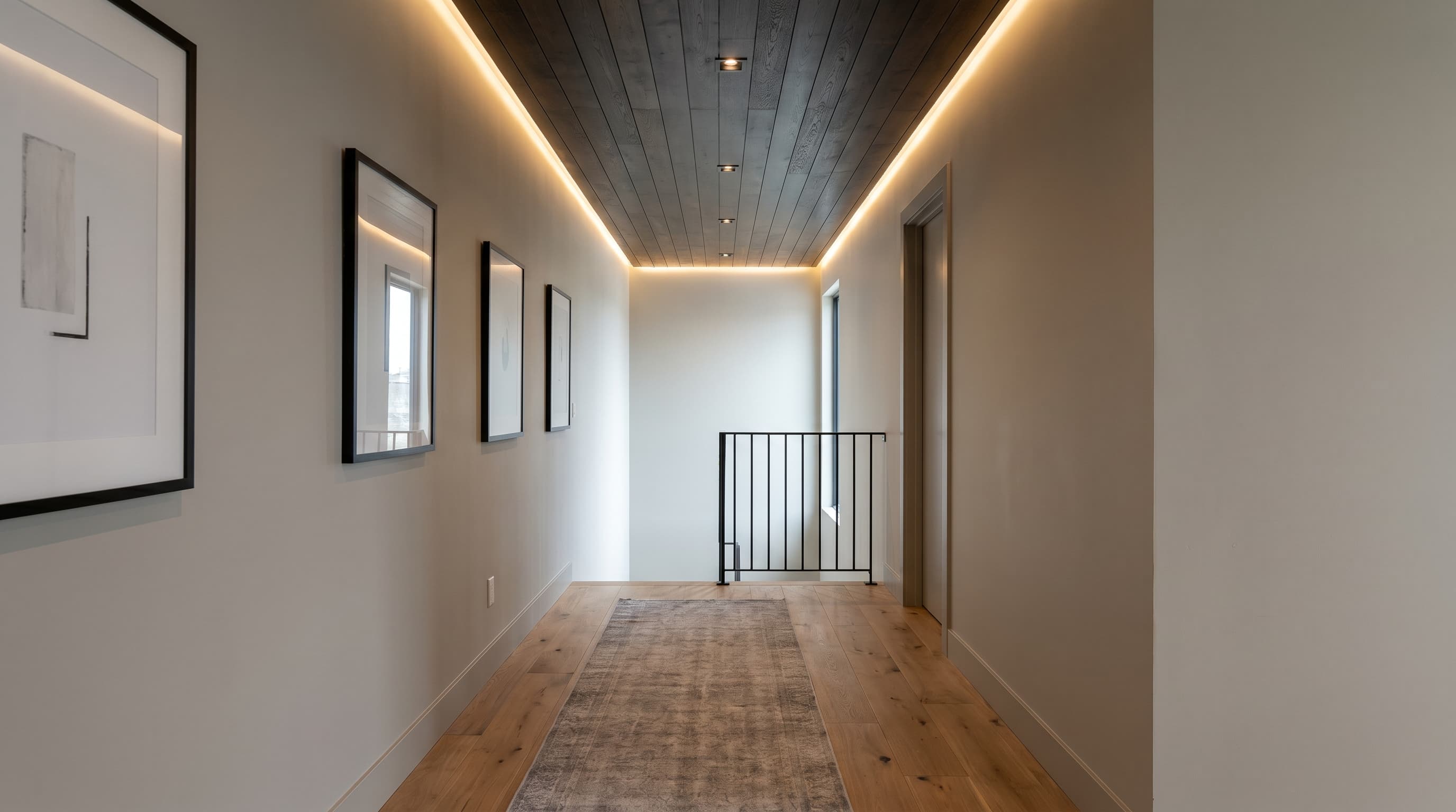 Modern hallway decor ideas featuring a dark planked ceiling, recessed lighting, framed artwork, and a neutral runner rug.