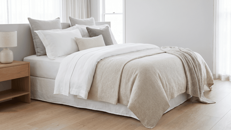 polished-hotel-style-bed-with-white-sheets-layered-duvet-and-decorative-pillows-in-a-bright-modern-bedroom