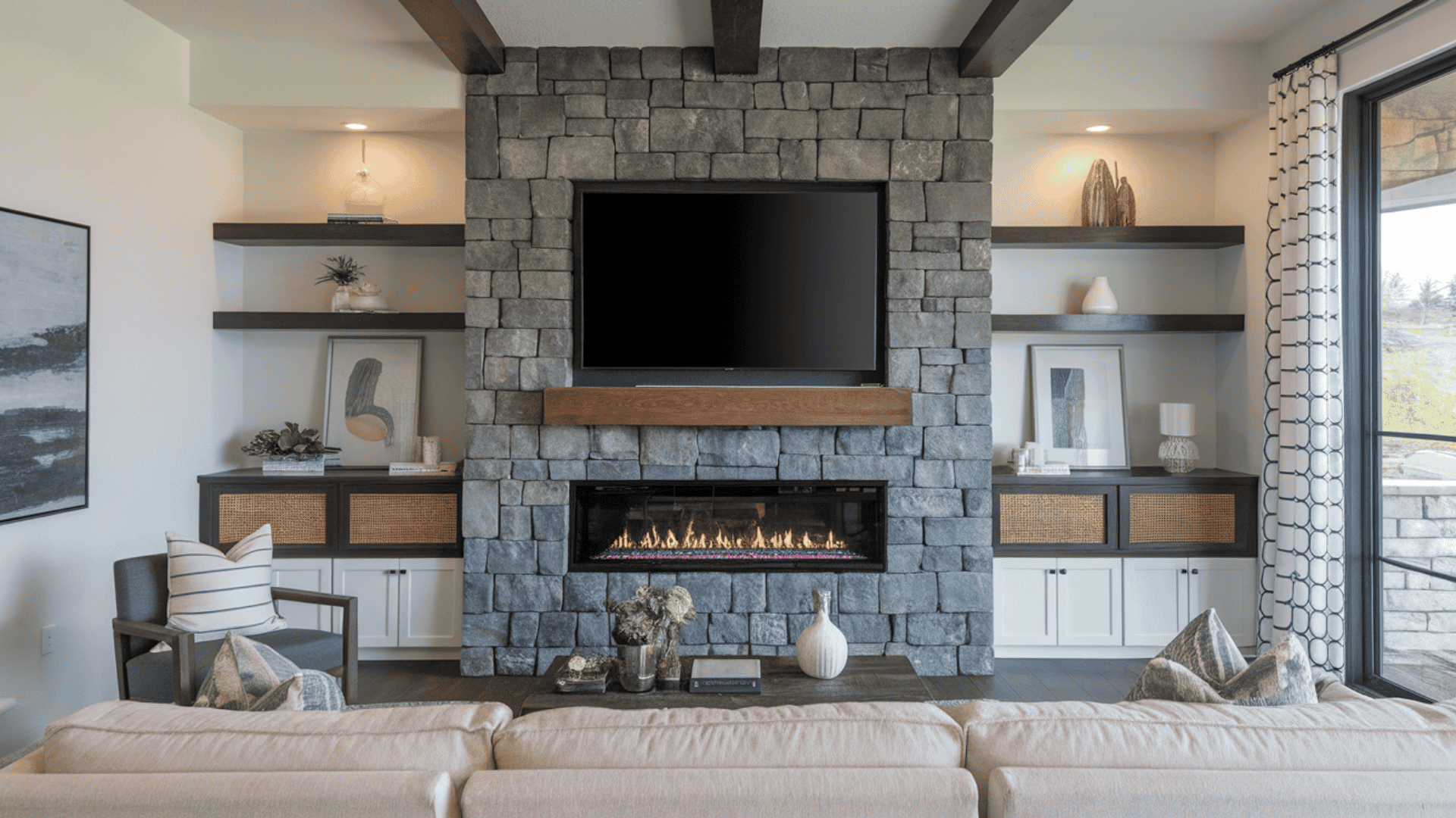 Modern living room with a gray stone fireplace wall framing a mounted flat-screen TV above a floating wood mantel.