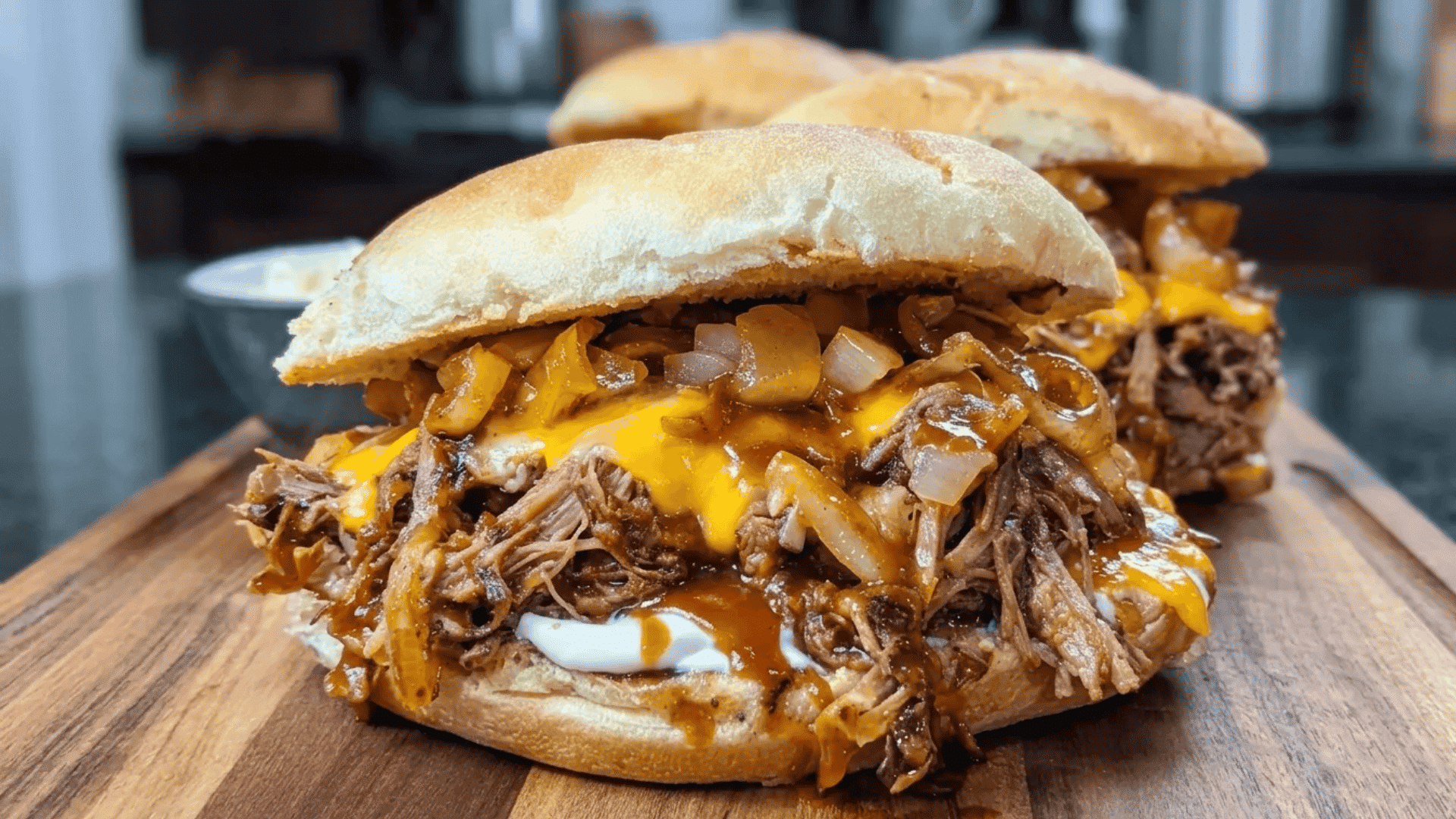 Slow cooker BBQ sandwiches loaded with tender shredded beef, melted cheese, and caramelized onions.