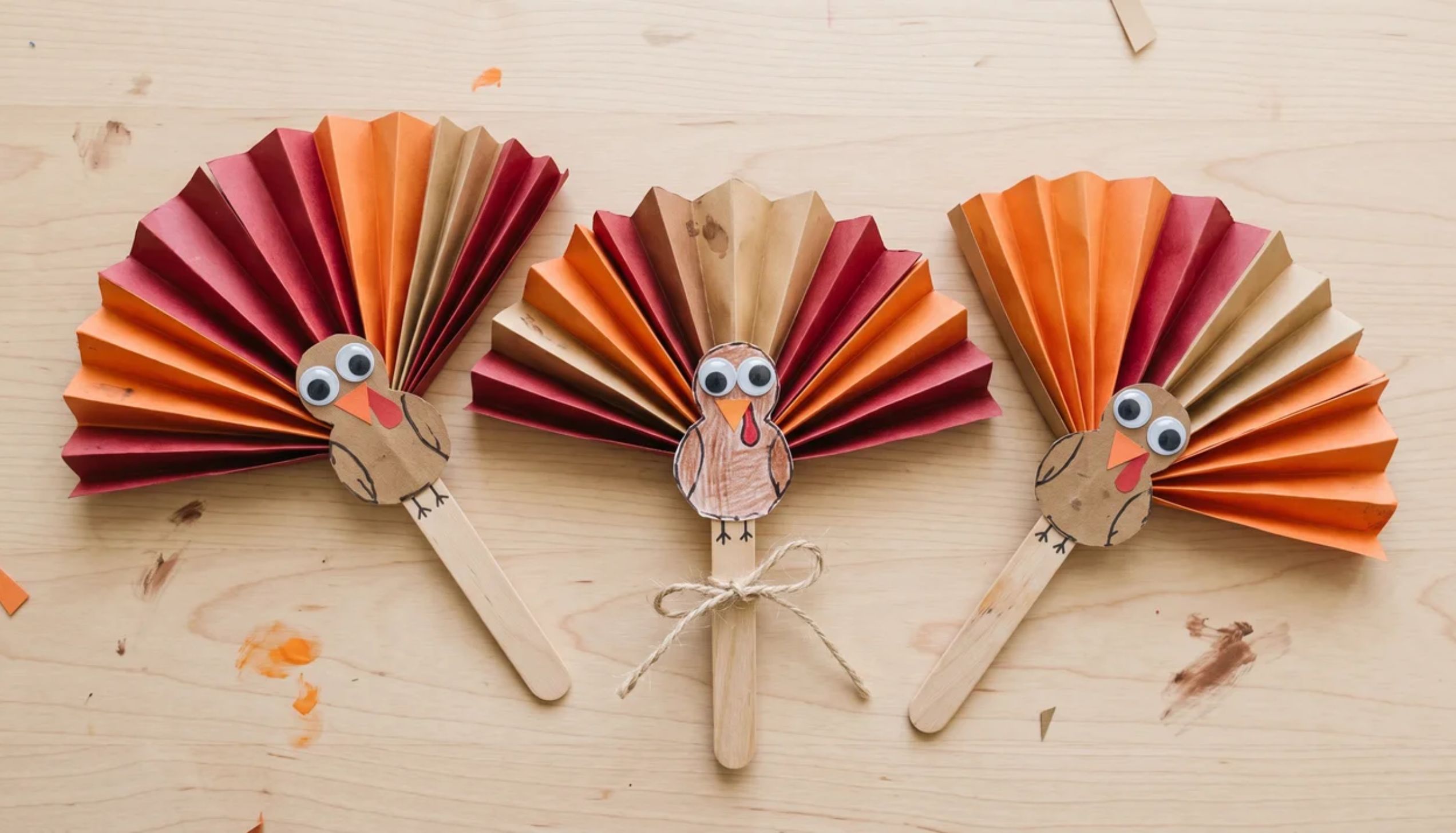 Three paper fan turkeys on popsicle sticks. One of many easy thanksgiving crafts.