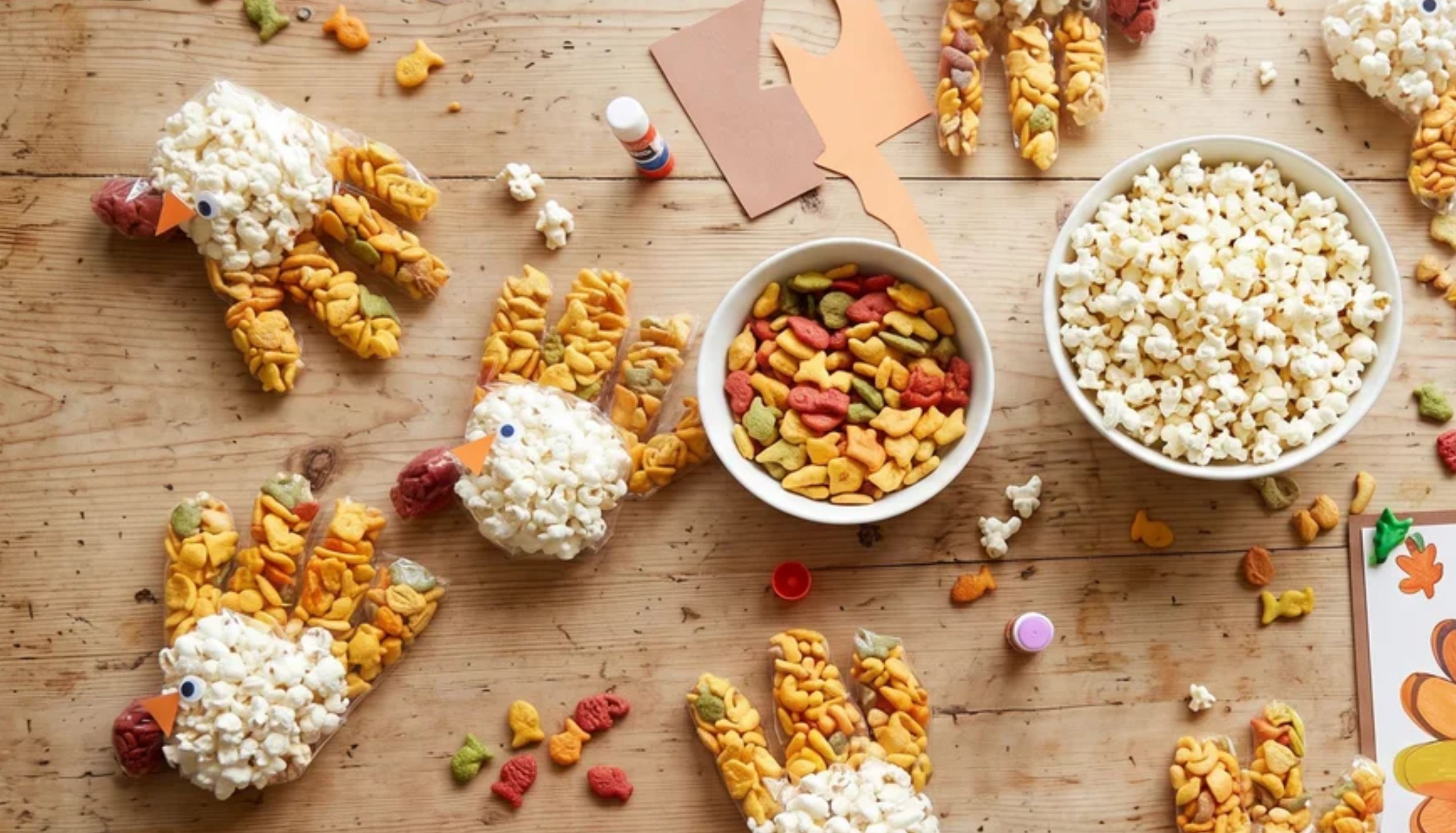 Clear popcorn bags decorated as turkeys with paper feathers and cardstock heads, easy Thanksgiving crafts and treats for kids