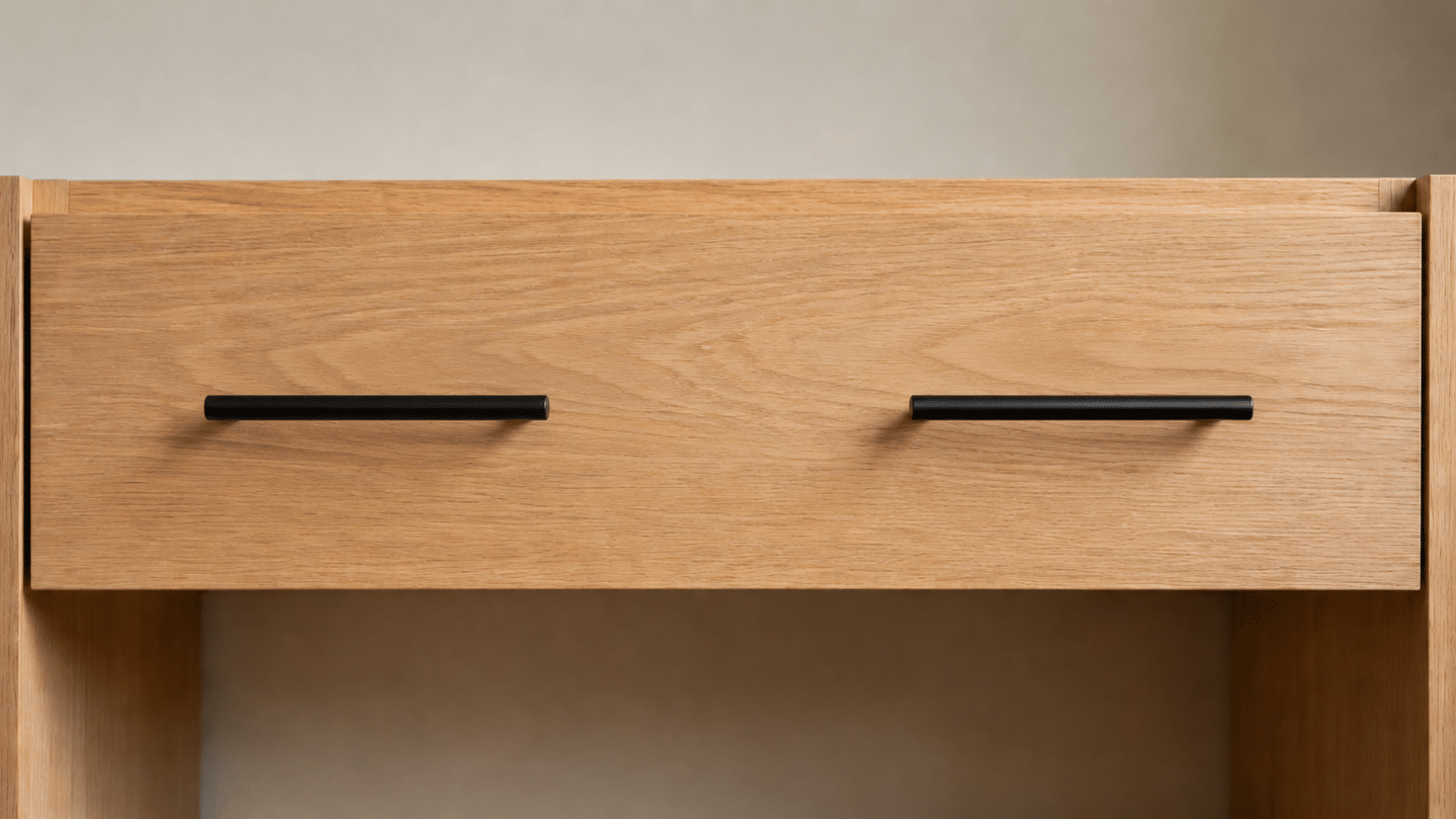 Wide wooden drawer with two black horizontal pulls spaced one-third in from each side, showing alignment and proportions.