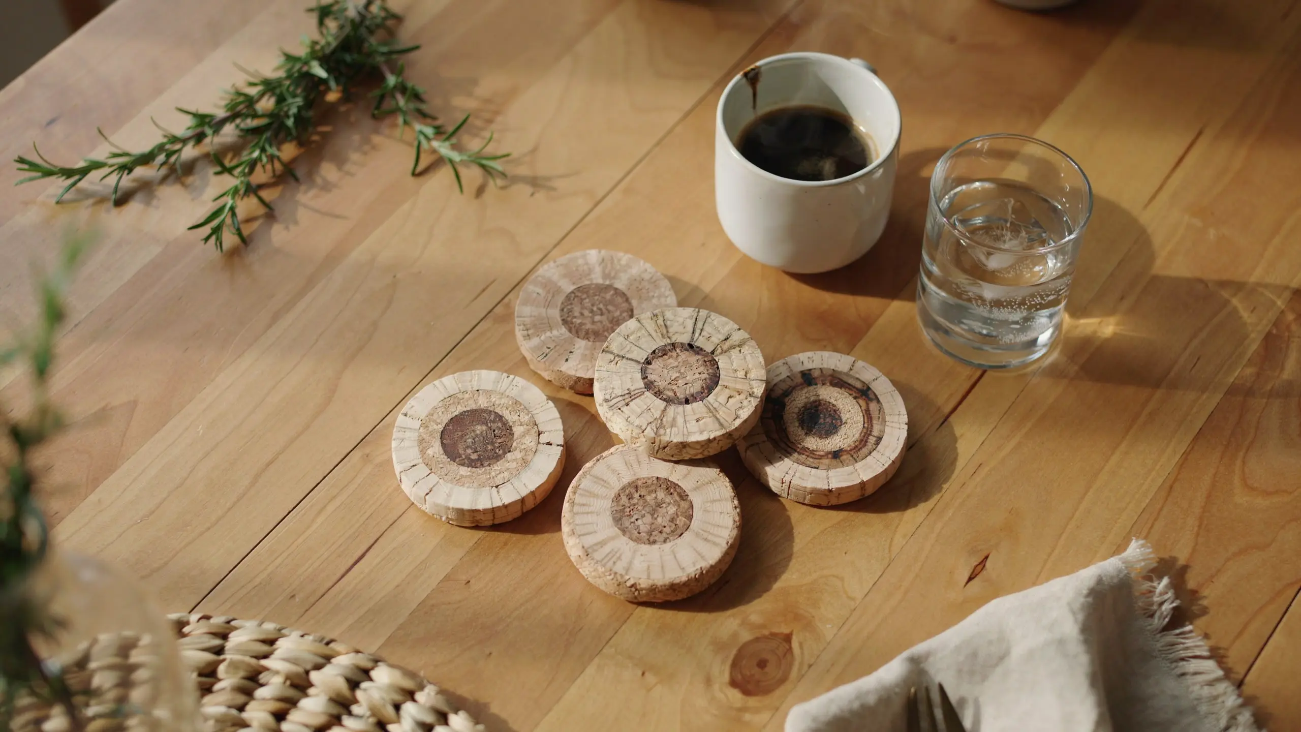 Wine cork coasters made from sliced corks on wooden table with coffee mug.