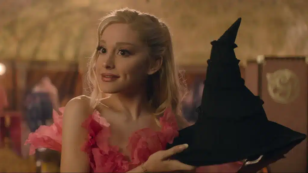 Ariana Grande appearing as Glinda in the Wicked movie wearing a pink costume.