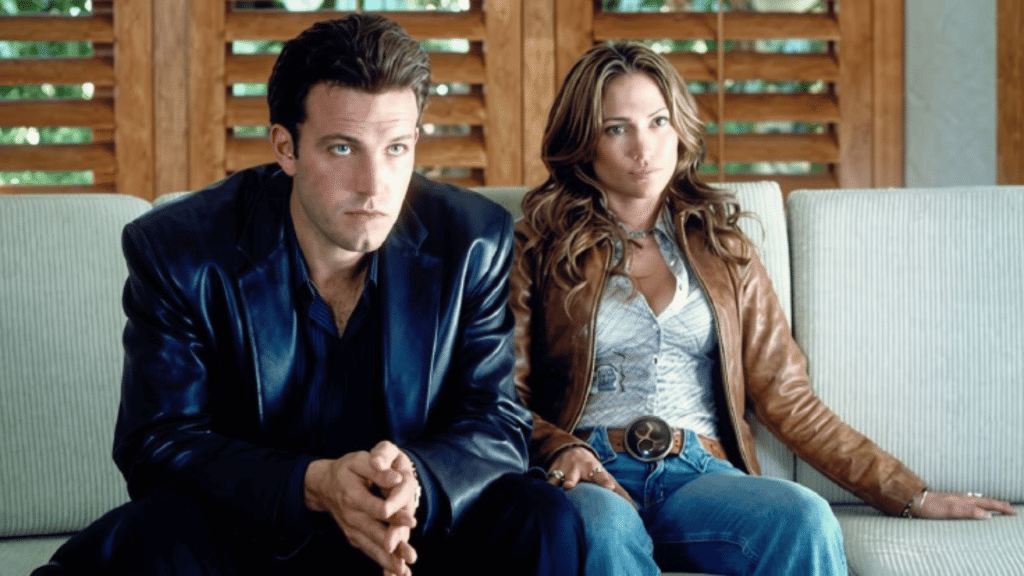 Ben Affleck and Jennifer Lopez sitting on a couch in a scene from the movie Gigli