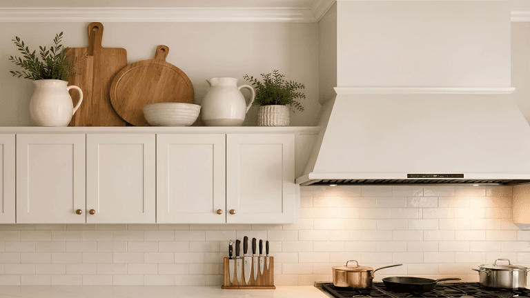 Kitchen with open shelf holding wooden cutting boards, ceramic bowls, pitchers, small plants, and a stove with cookware.