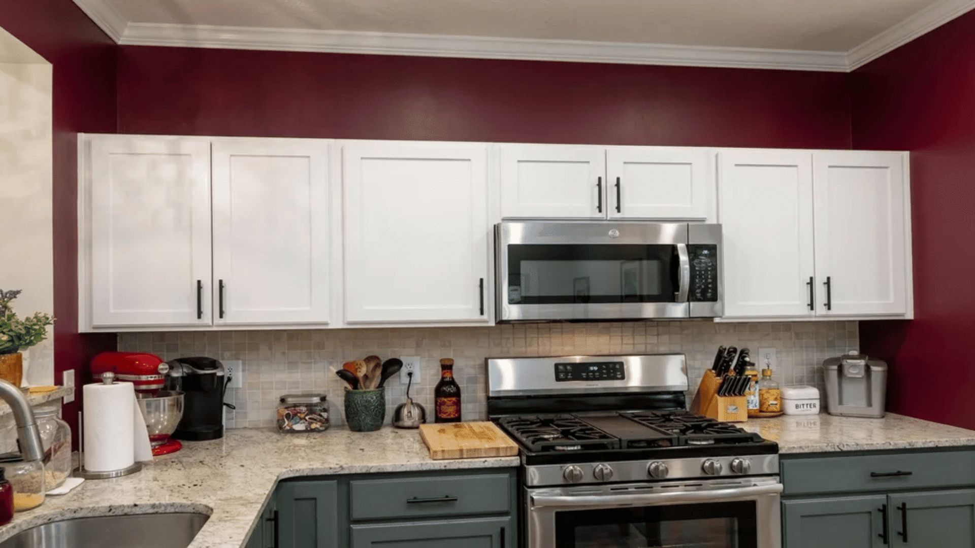 Dark burgundy wall above white kitchen cabinets serving as a decor element.