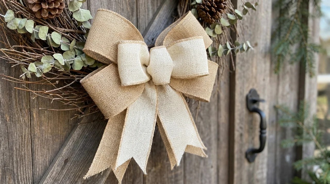 Double-layered burlap bow with full loops displayed on a large rustic wreath decoration.