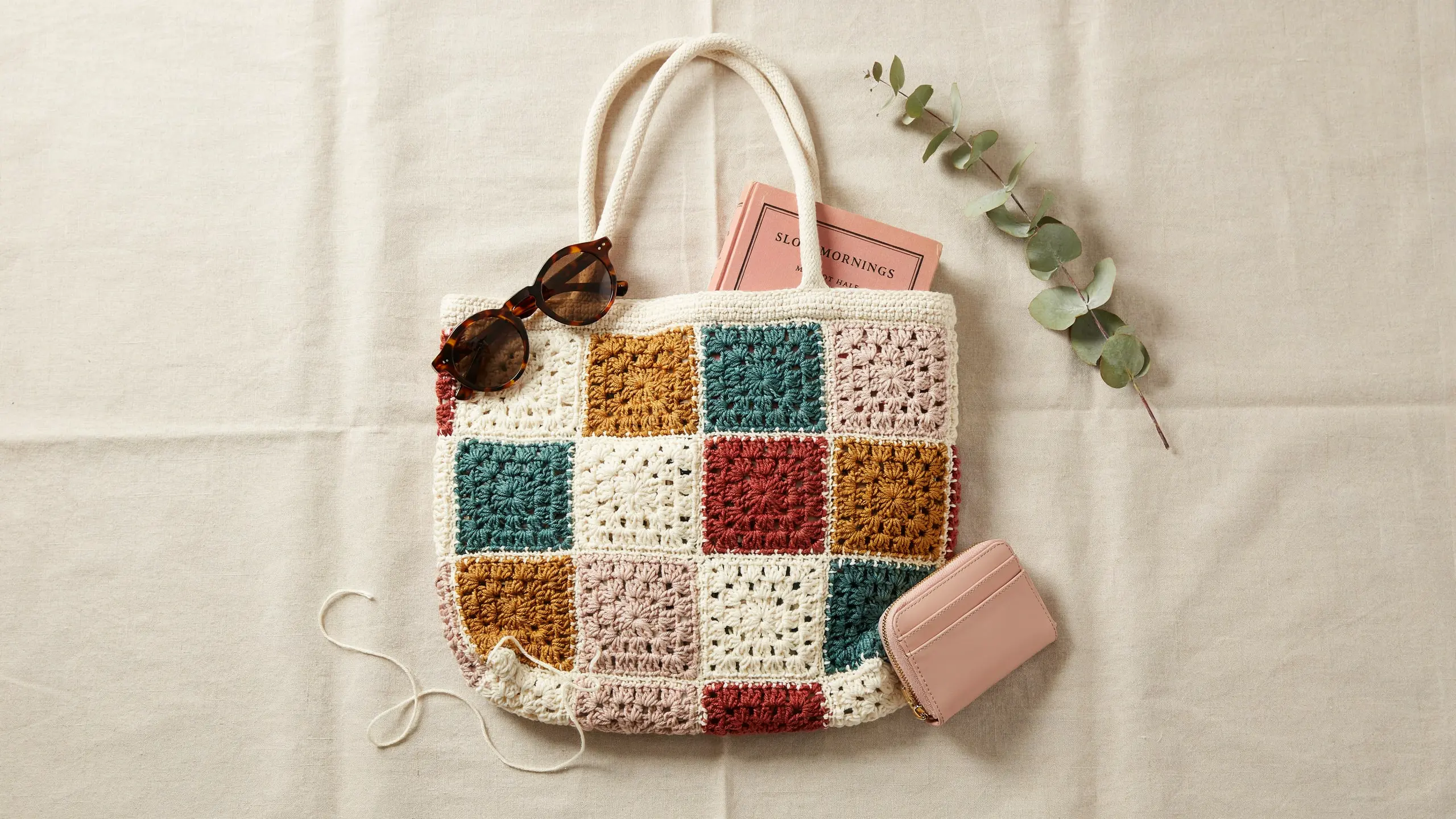 Colorful granny square crochet tote with bold squares and long handles.