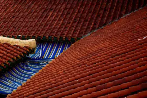 Red tiled roofs overlapping with blue and yellow striped architectural detail beneath