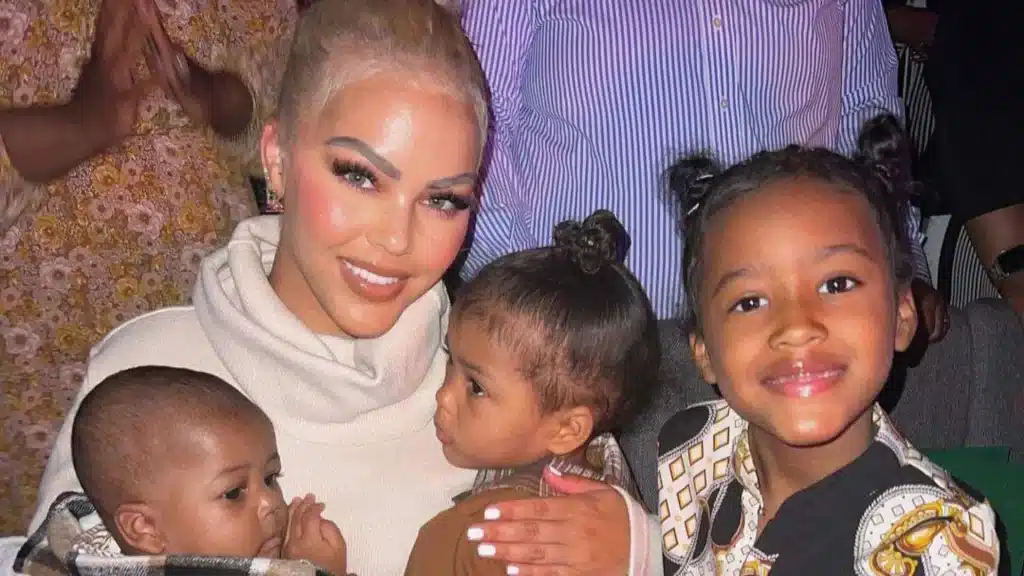 Jacky Oh with her three children in a family portrait highlighting her role as mother.