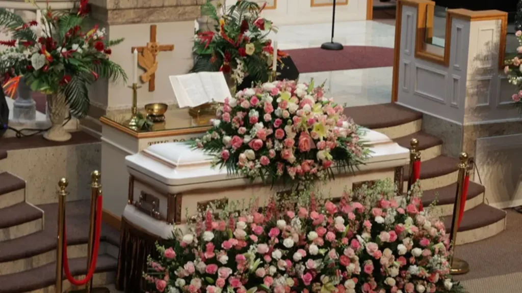 Funeral service for Jacky Oh featuring floral arrangements, casket, and memorial setup honoring her life and legacy.